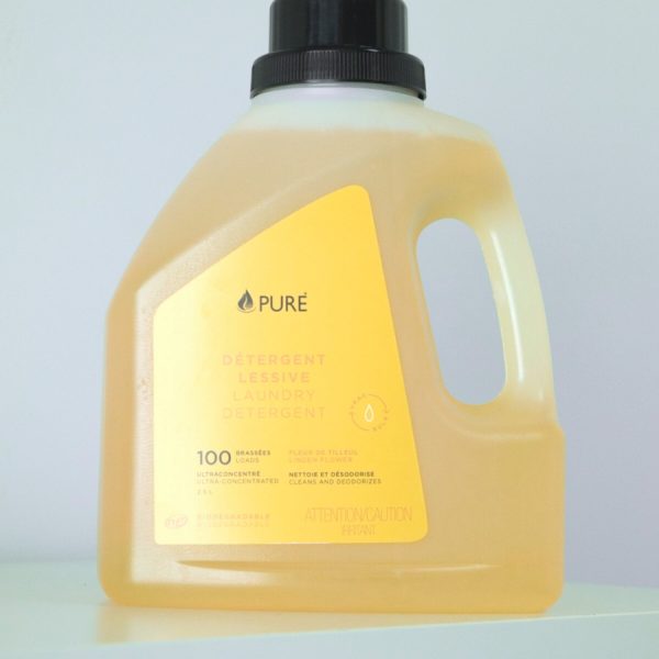 Pure brand organic and biodegradable laundry detergent in a clear bottle with orange label.