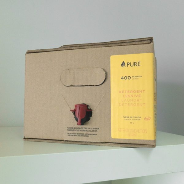 Pure brand organic and biodegradable laundry detergent in bulk, stored in a box with a dispenser for refills.